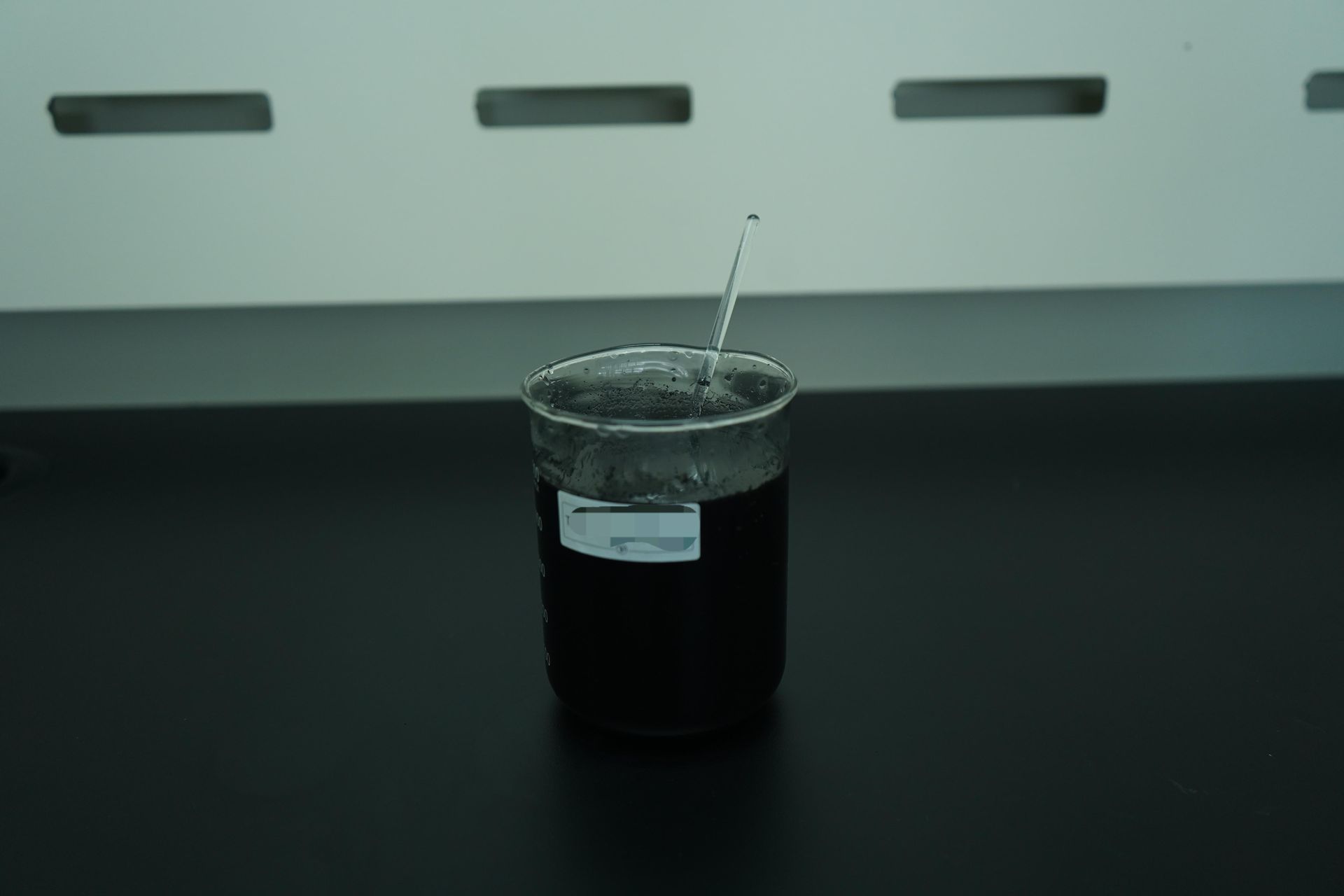 Dark liquid in a beaker showing botanical carbon extraction from banyan leaves
