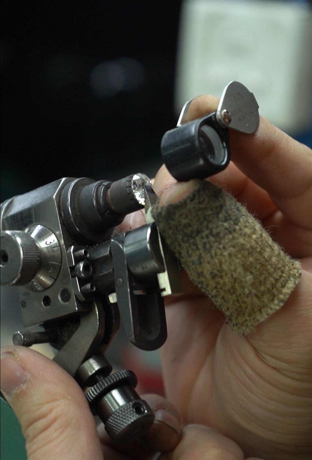 Quality inspection of a finished memorial diamond at the bench — the consistency premium retail depends on