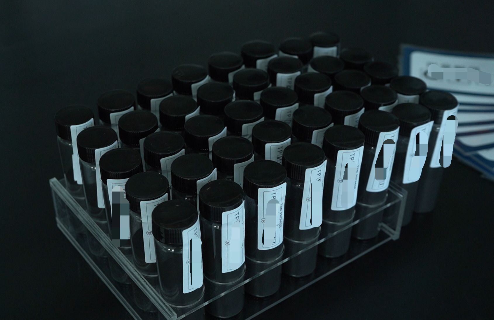 Collection of carbon sample vials organized in a laboratory rack for memorial diamond production
