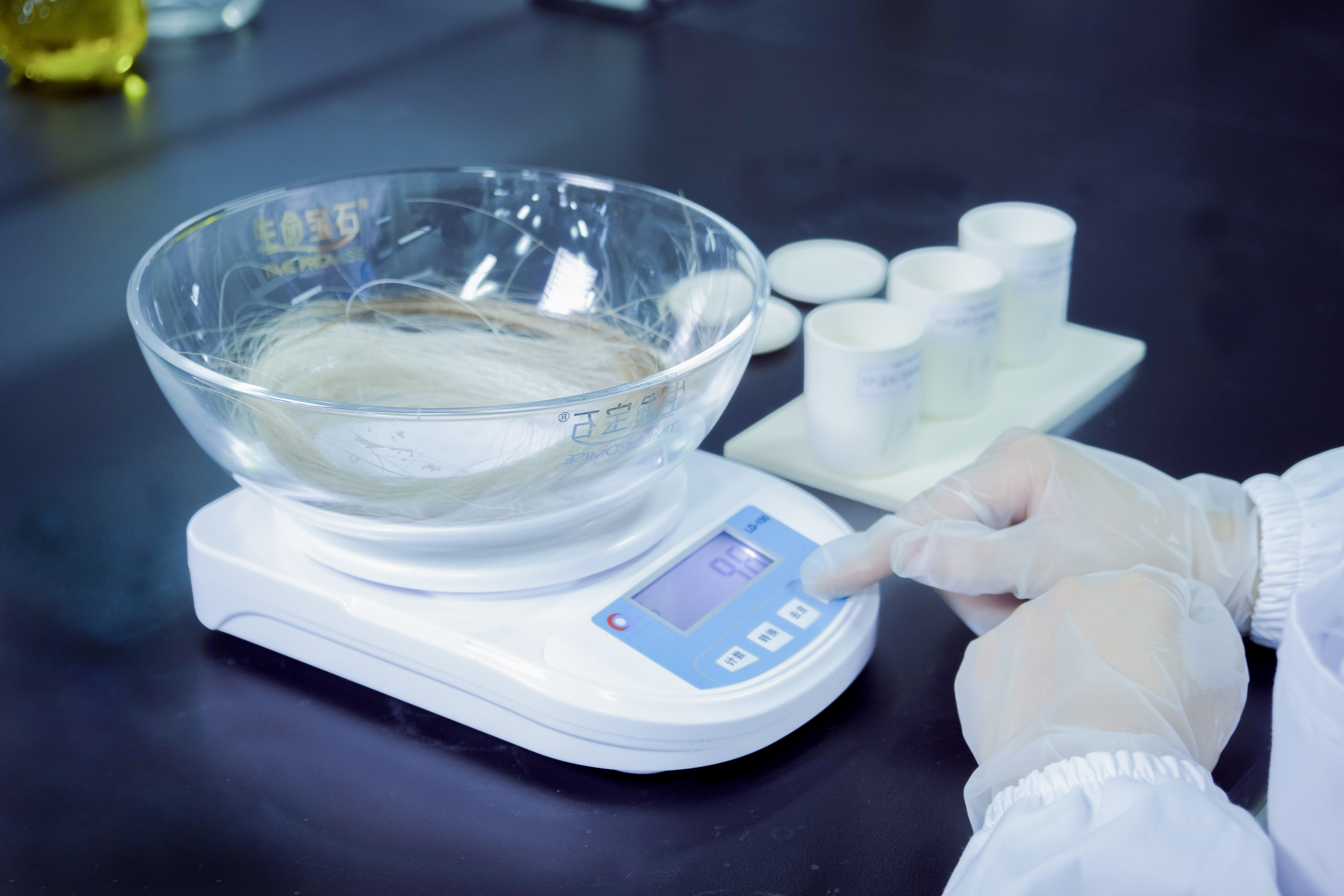 Laboratory technician weighing carbon samples with precision balance