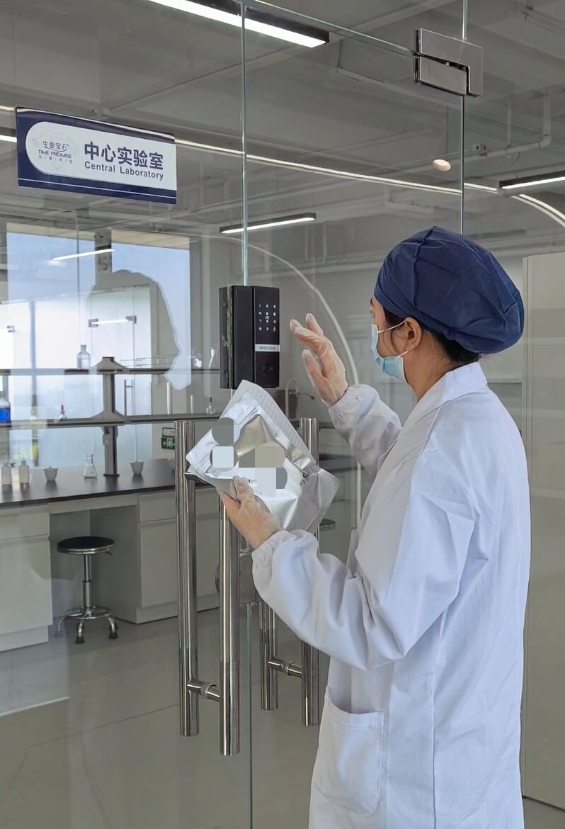 Laboratory technician entering the central processing area of a memorial diamond manufacturing facility during an audit walkthrough