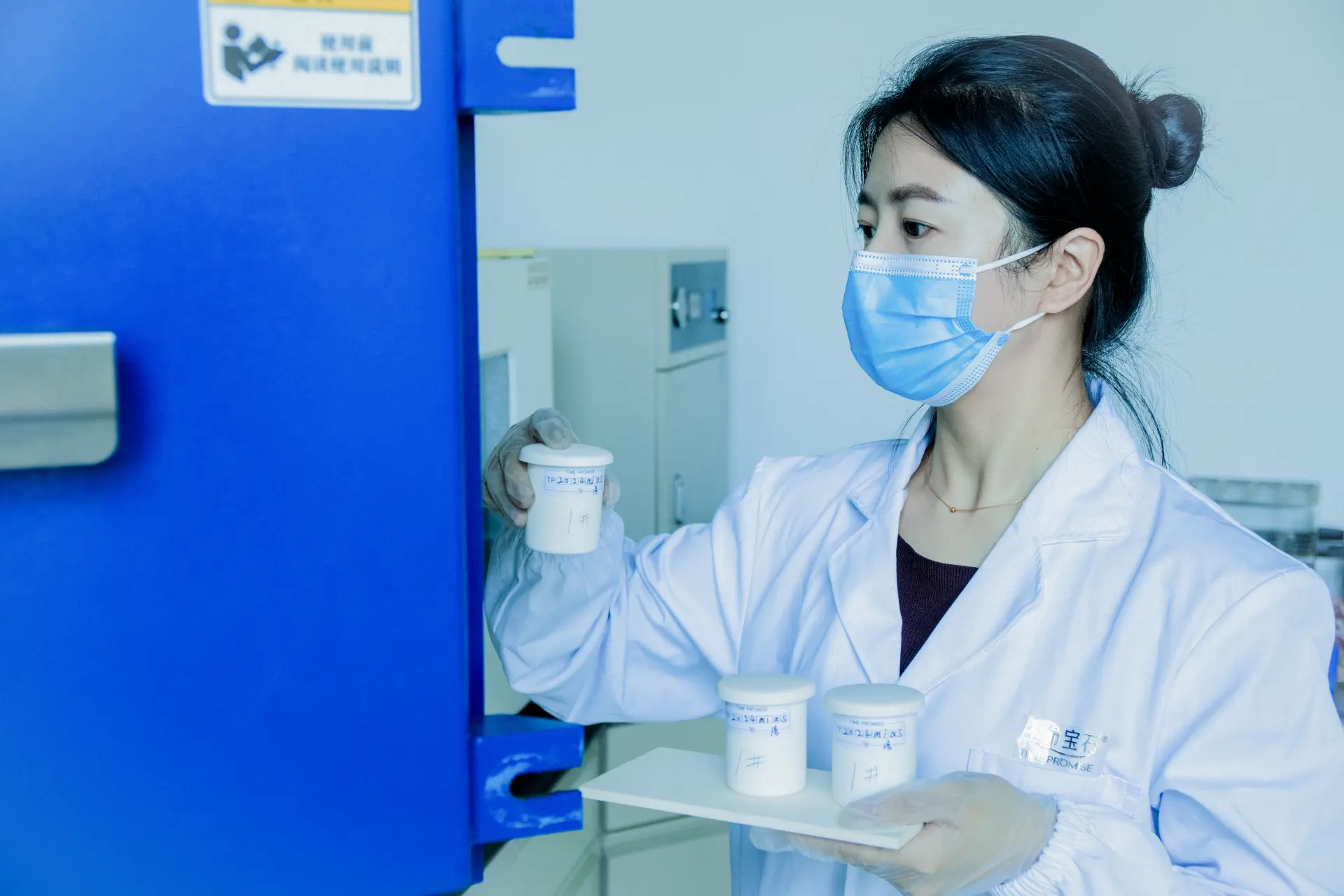 Technician placing sample crucible into high-temperature graphitization furnace