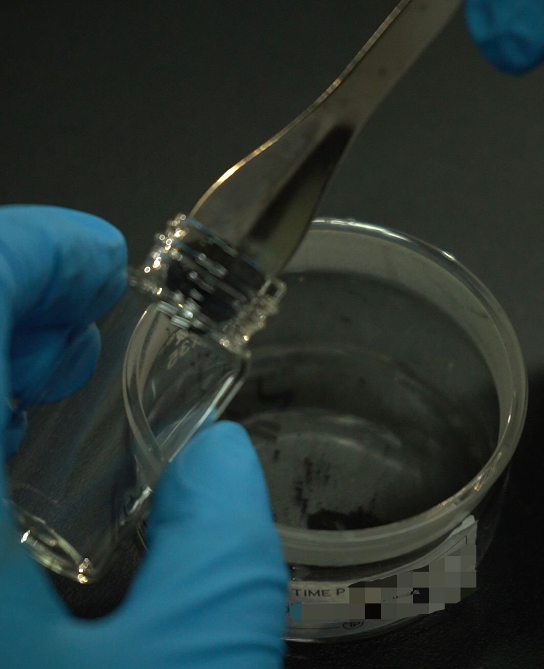 Laboratory technician in protective equipment handling diamond synthesis materials