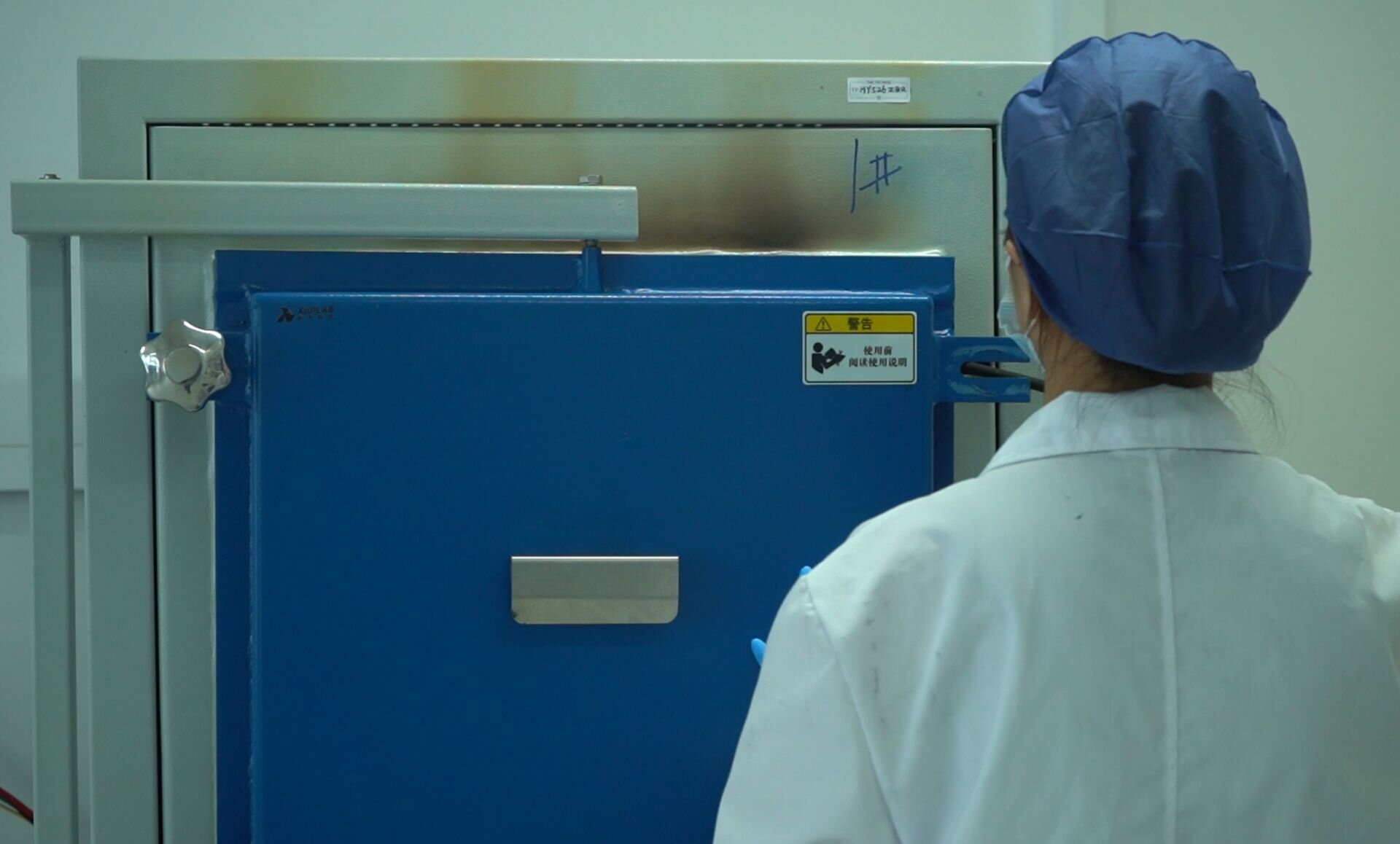 Technician operating HPHT synthesis chamber equipment in a laboratory setting